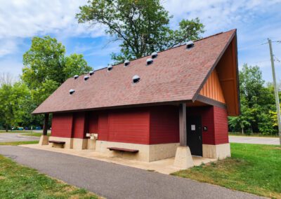 a red building with a red roof and a bench in front of it - Bald Eagle Lake Park Daylighting Project