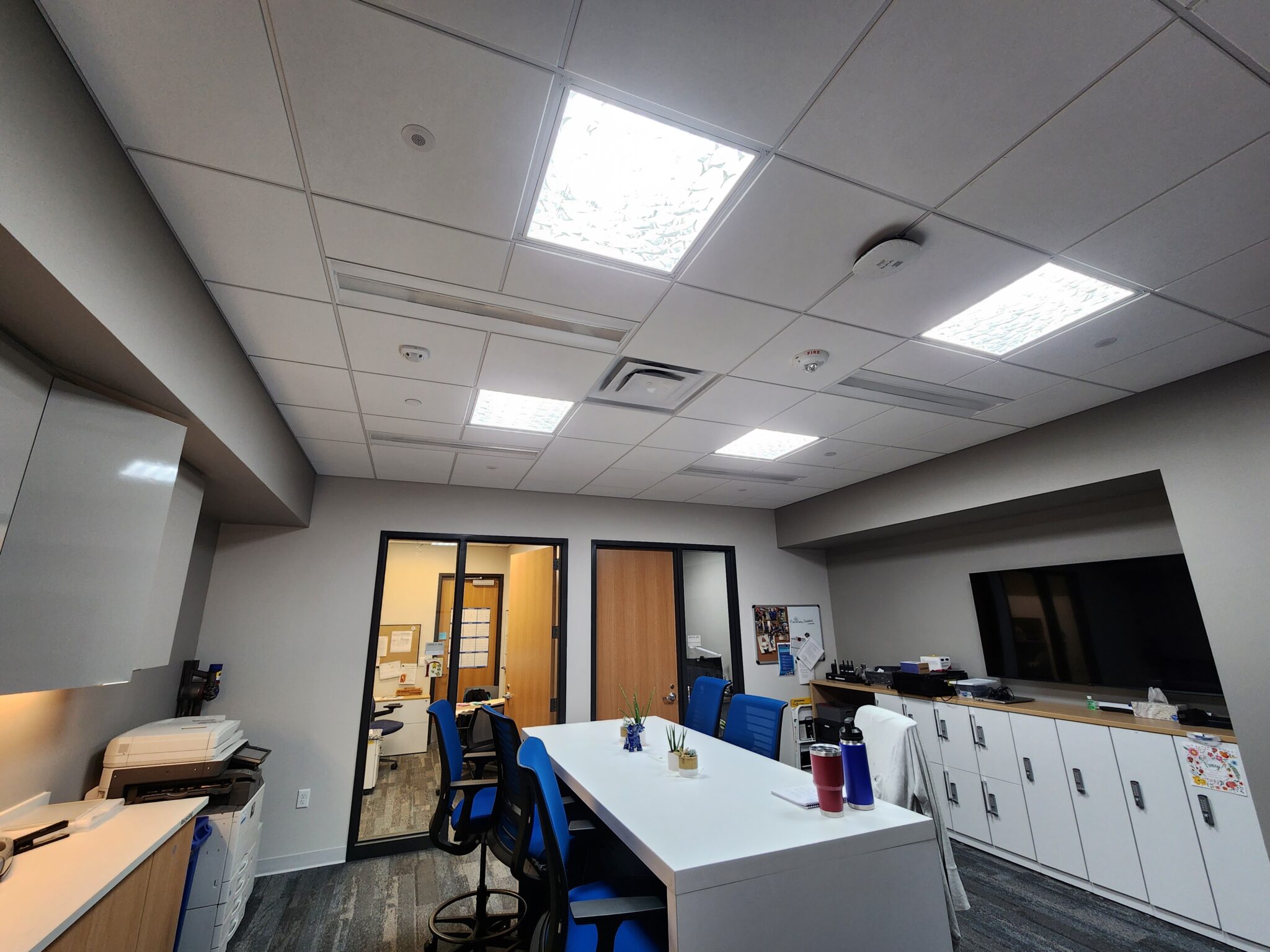 a room with a desk, chairs, and a television - City of Plymouth Community Center Project