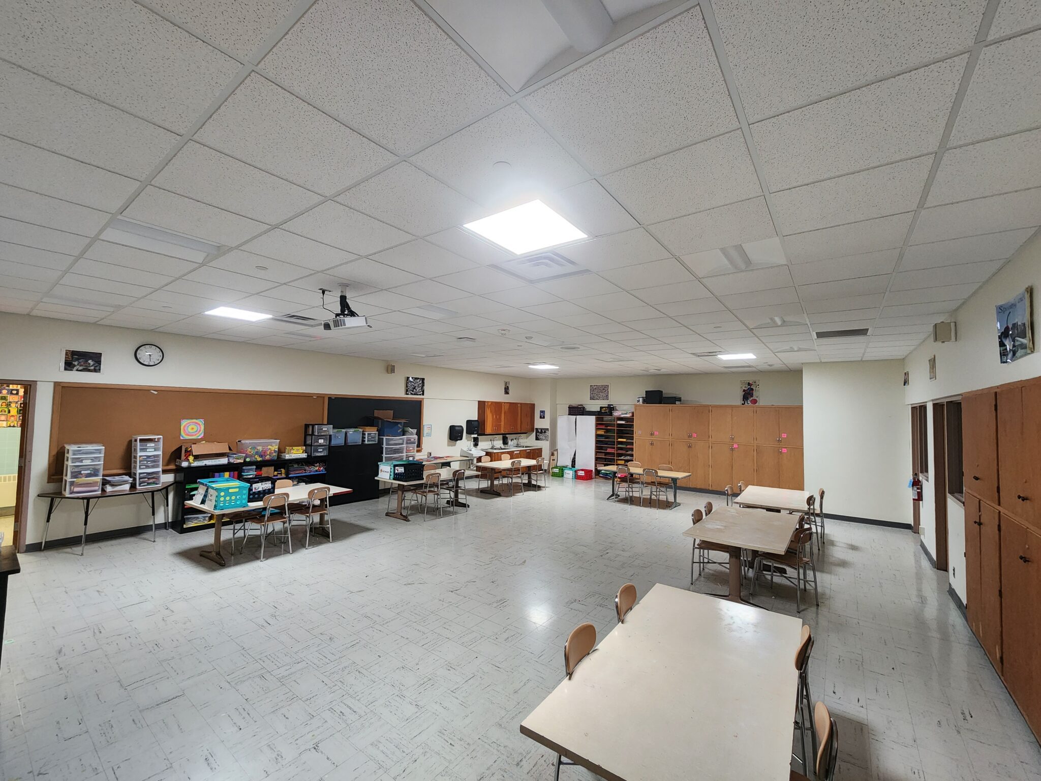 a classroom with tables, chairs, and a clock - Franklin Elementary School